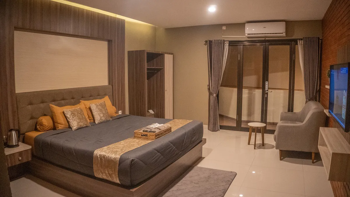 Kamar Sumatra Albani's House dengan jendela luas dan cahaya alami